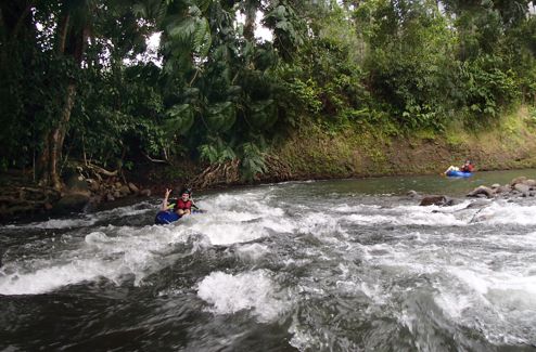 Two people entering white water area while tubing with LaFinca Costa Rica