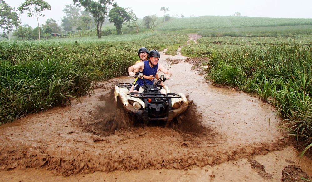 ATV driving through mud in sugar cane field 